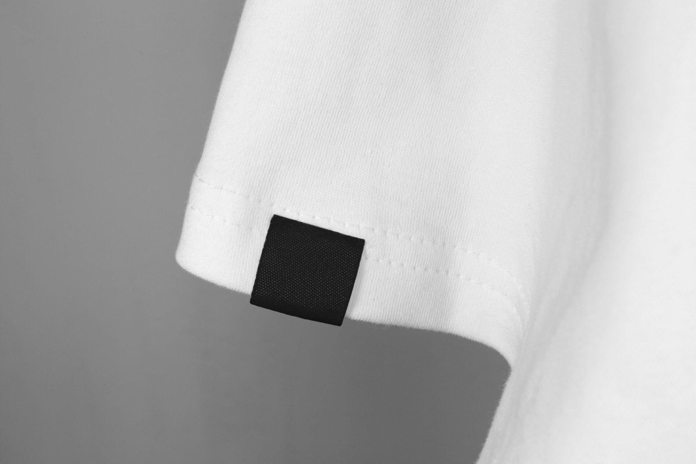 blank black color clothing label on white t shirt sleeve